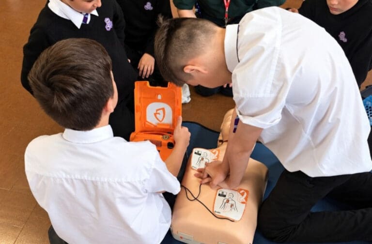 Schoolchildren practising CPR and AED use at a Calon Hearts session
